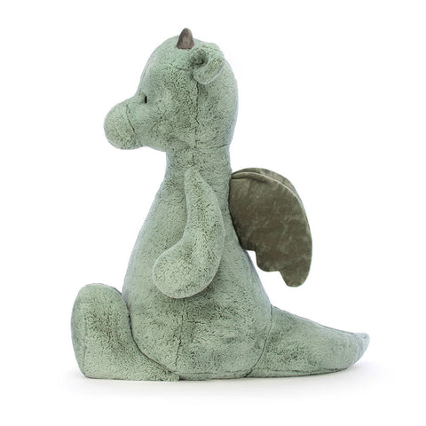 Side view of a Green plush dragon toy on a white background