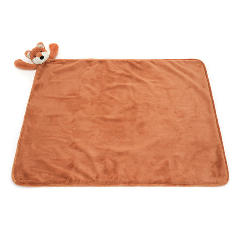 Orange plush blanket with a small fox toy on a white background