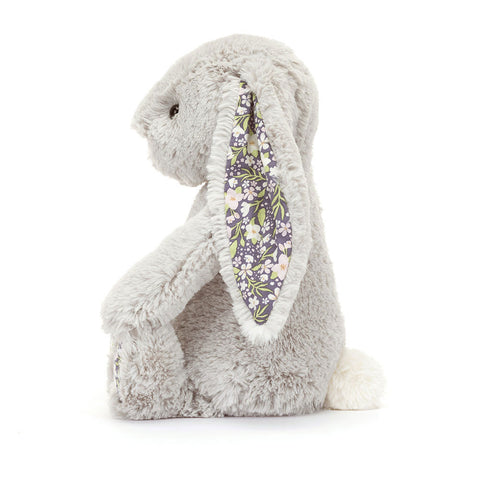 Side view of a Silver Plush toy rabbit with floral ear on a white background
