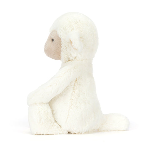 Side view of a plush lamb toy on a white background