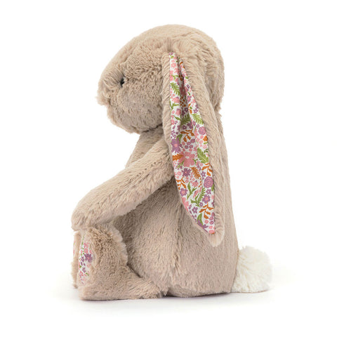 Image shows a side view of the beige stuffed bunny with floral fabric in its ears