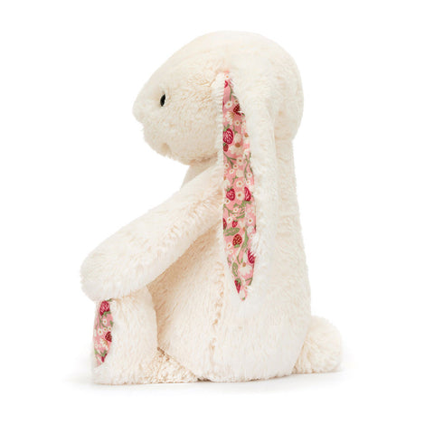 Image shows a side view of the cream stuffed bunny with strawberry fabric in its ears