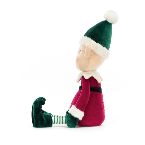 Side view of a Plush toy elf with green hat and red outfit on a white background