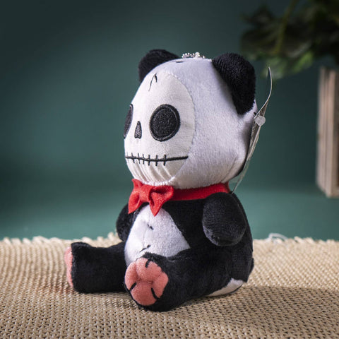 Image shows a side-angle view of the stuffed panda with the skeleton face