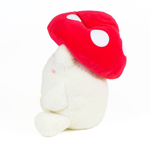 Image shows a side view of the stuffed frog wearing a mushroom hat