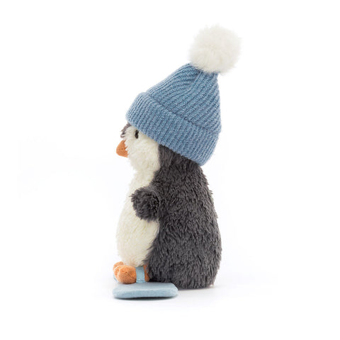 Side view of the plush penguin toy on a snowboard