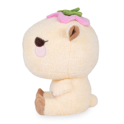 Side view of a plush capybara with a pink flower on its head