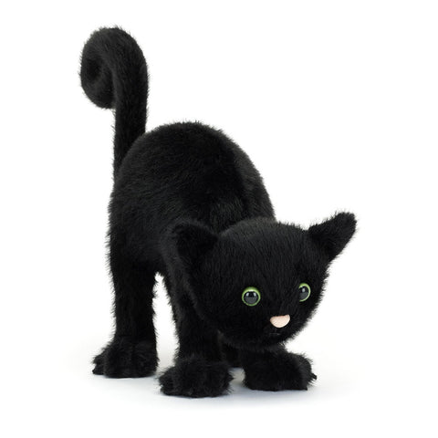 Plush black cat toy on a white background. Its tail is up, and its back is ached.