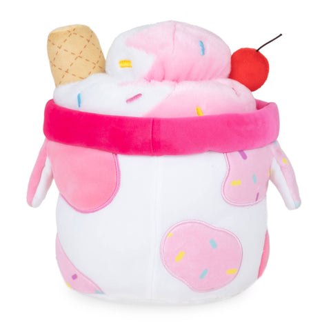 Back view of a plush milkshake in a pink, cow-themed cup with a cherry on top