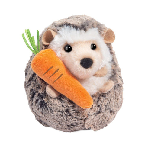 Plush toy hedgehog holding a carrot on a white background