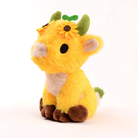 Bright yellow plush cow with sunflowers on its head