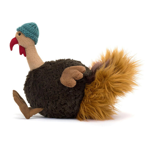 Side view of a Plush toy resembling a turkey with a knitted hat on a white background