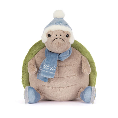 Plush turtle toy wearing a hat, scarf, and ice skates on a white background