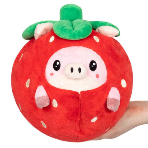 A plush pig wearing a strawberry costume held in an adult's hand