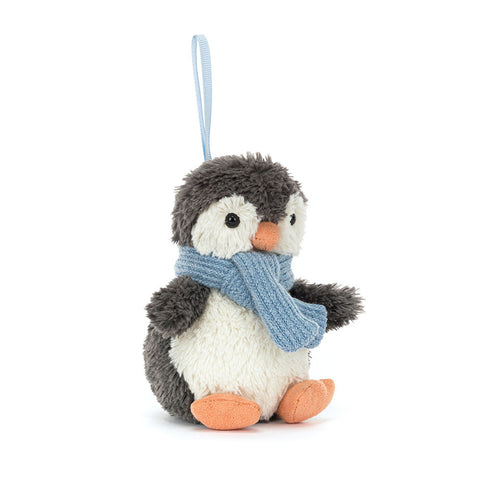 Stuffed penguin toy with a blue scarf on a white background. Hanging from a blue ribbon.