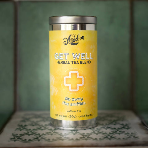 Yellow tea canister labeled 'Get Well' on a patterned surface with a green background