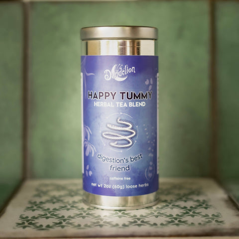 Tea canister labeled 'Happy Tummy' on a patterned surface with a green tiled background