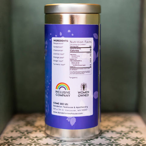 Tin tea container with a purple label on a green surface. Label lists ingredients and nutrition facts