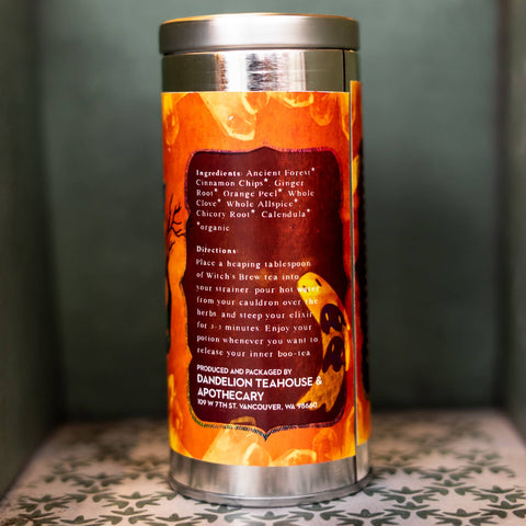 Tea canister with Halloween-themed design and text on a dark background. Label lists ingredients.