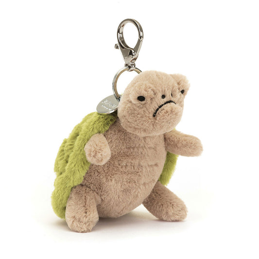 A stuffed turtle with a frowny face hanging from a clip keychain