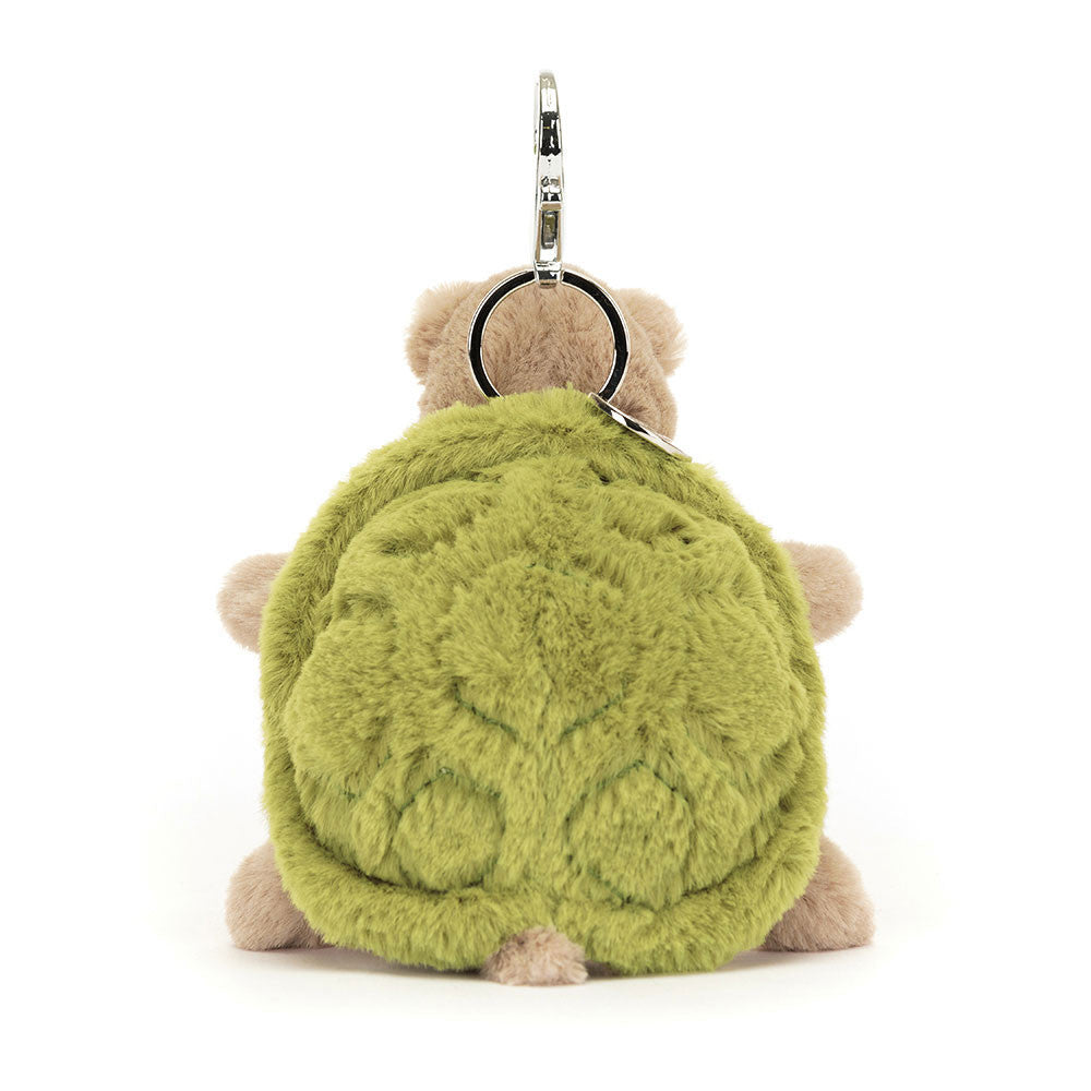 The back view of a stuffed turtle hanging from a clip keychain