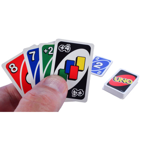 Image shows an adult hand holding the tiny uno cards. it is about the size of half of a finger.