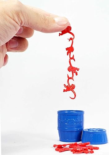 Image shows an adult hand holding the monkeys. One monkey is slightly larger than the adult's thumbnail.