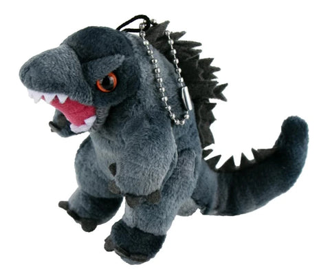 Image shows the world's smallest Godzilla plush. It has a silver chain attached to its head.