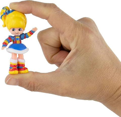 Image shows the world's smallest Rainbow Brite held between and adult's thumb and forefinger.