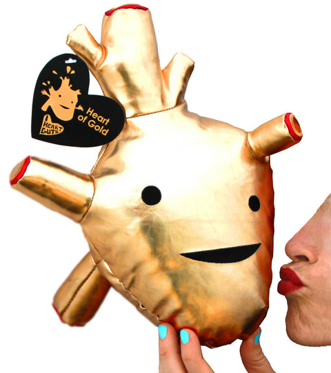 Image shows a woman pretending to kiss a stuffed golden heart