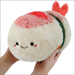 Two hands hold a plush shrimp sushi on a white background. It has a happy face.