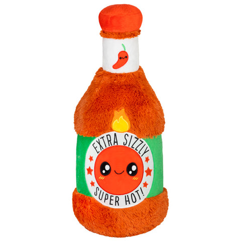 A plush toy designed to look like a bottle of hot sauce with a cartoon face on the label.