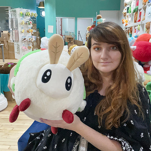 A woman holds the plush Luna Moth. It is about the size of her torso.