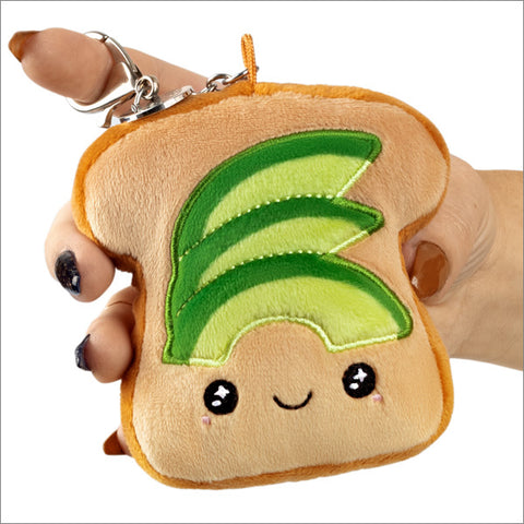 A plush avocado toast attached to a silver keychain clip