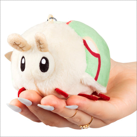 A plush toy resembling a Luna Moth with a green and beige color scheme, featuring a metal clip and held in a person's hand.
