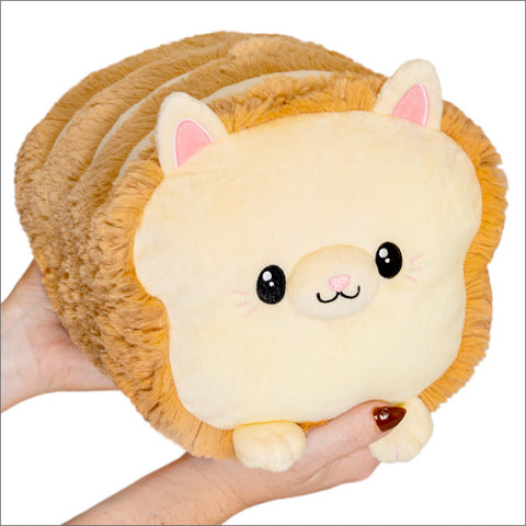 A plush toy resembling a loaf of cat-shaped bread, with a soft beige color and cat ear details.