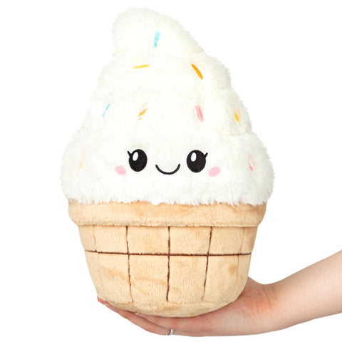 A plush vanilla ice cream cone held in someone's hand