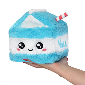 A hand holding a blue and white stuffed toy shaped like a mini milk carton with a character face on it.