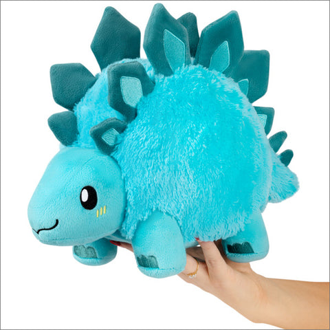 A light blue plush Stegosaurus held in someone's hand