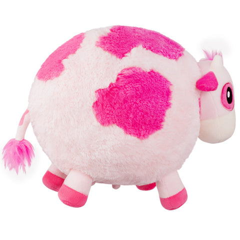 A side view of the plush strawberry cow. Its body is very round.