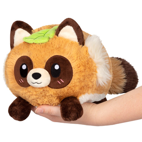 A plush toy resembling a Tanuki, which is a Japanese raccoon dog, with a beige, brown, and white color scheme. The toy has a round body, big eyes, and a bushy tail.