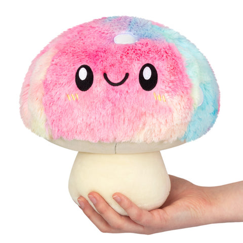 A plush pastel tie-dye mushroom held in someone's hand