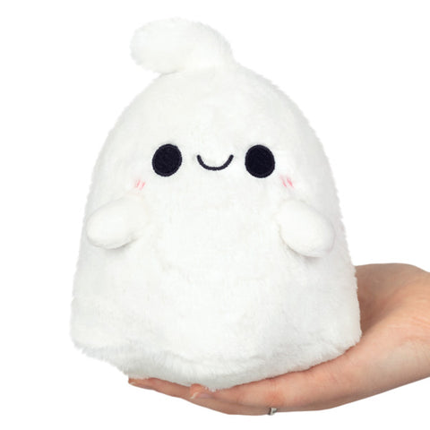 A plush ghost with a happy face held in someone's hand
