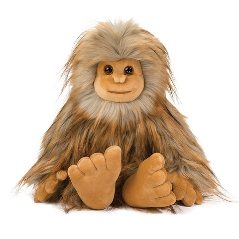 Image shows a long-haired stuffed Sasquatch. It is seated.